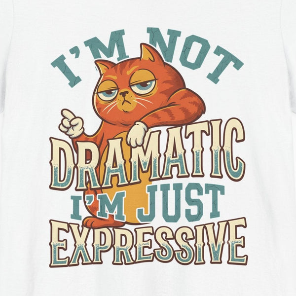 Close-up of the I'm Not Dramatic print: orange tabby with one paw raised under retro lettering, on the White tee